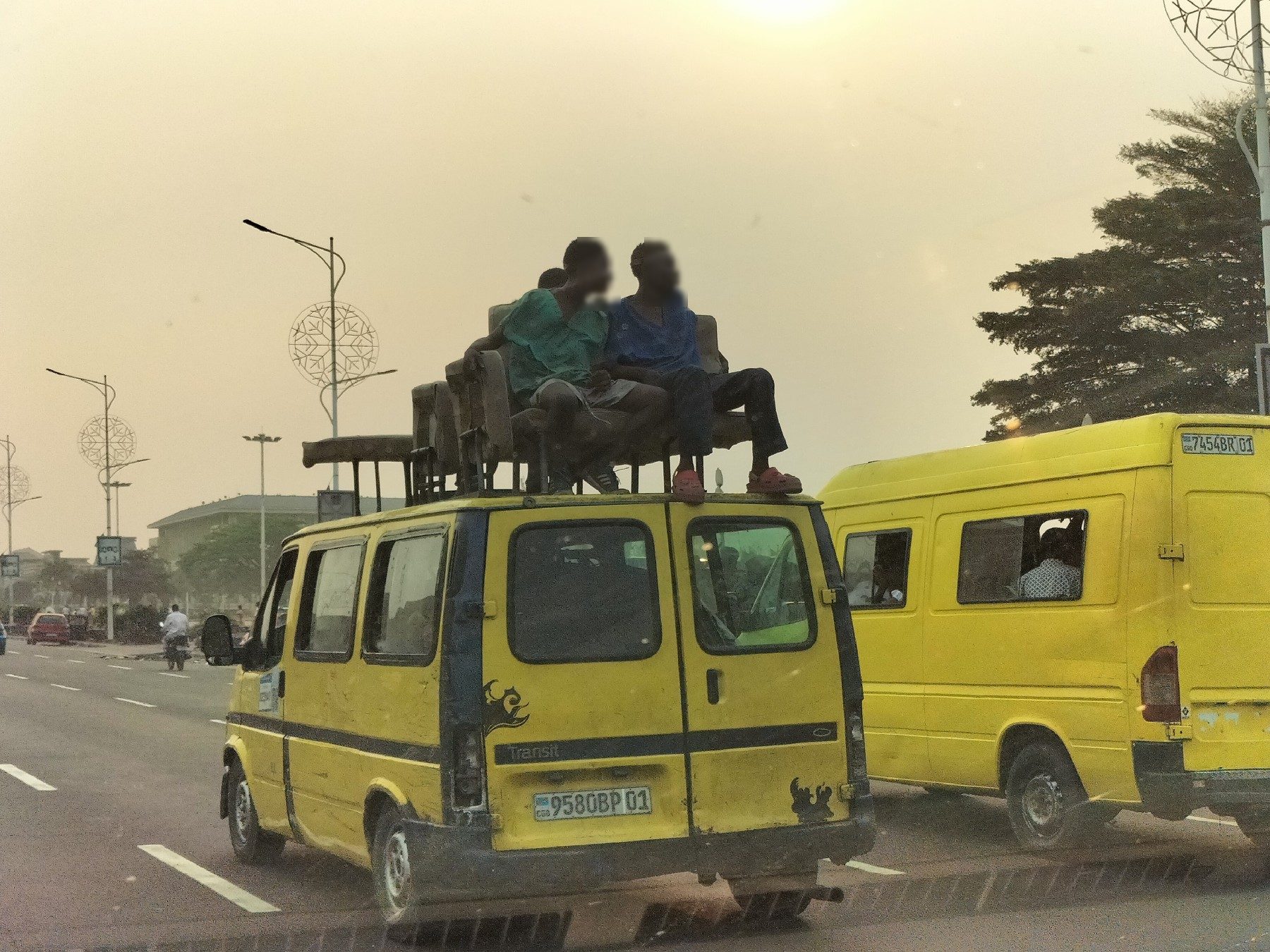 Bus jaune de Kinshasa avec des passagers sur le toit